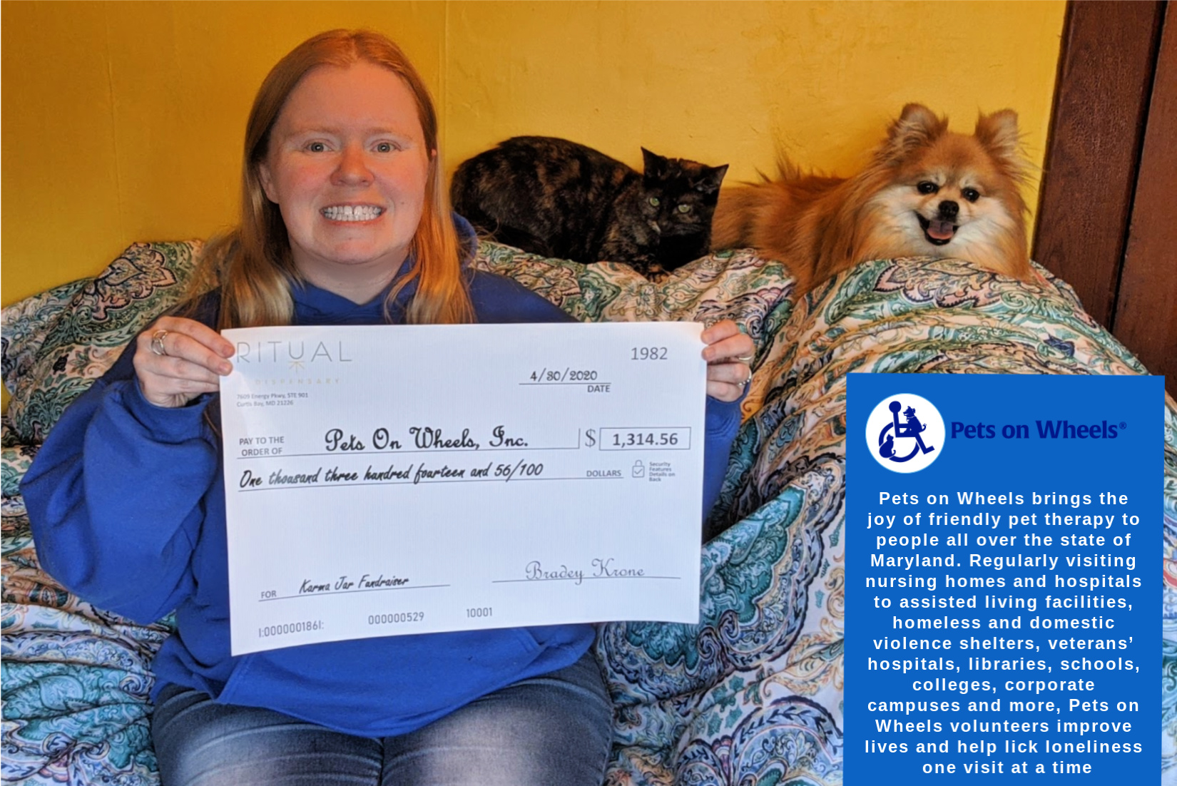 Ritual Pets on Wheels donation lady smiling with check with dog and cat in background