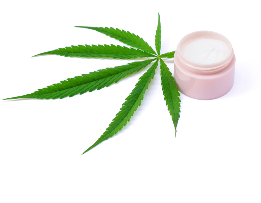 Jar of CBD cream with raw marijuana leaf